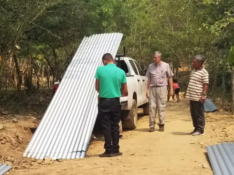 Cette photo illustre l'une des actions promouvant le développement intégral du Honduras : le soutien des paroisses honduriennes. En effet, à la demande de la paroisse d'Olanchito, des tôles ondulées ont été financées pour permettre la reconstruction du village d'Olanchito.